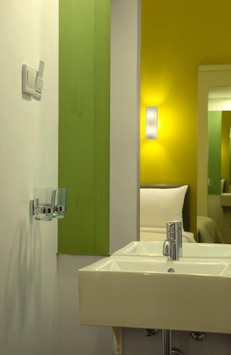 a bathroom with a sink and a mirror at Amaris Hotel Sunset Road - Bali in Kuta