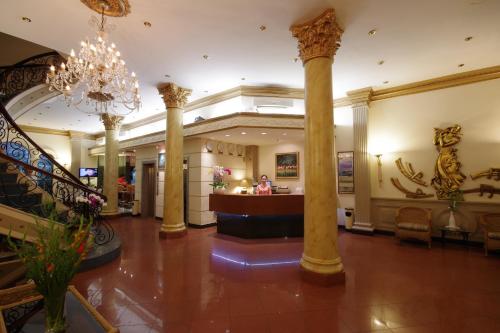 a lobby of a hotel with a chandelier and columns at The Spring Hotel in Ho Chi Minh City