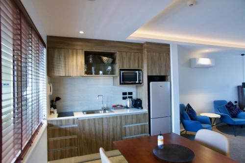 a small kitchen with a table and a refrigerator at Regal Palms Resort in Rotorua