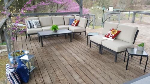 a patio with couches and tables on a wooden deck at Nantahala Village in Bryson City