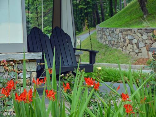two blue chairs sitting in a garden with flowers at Nantahala Village in Bryson City