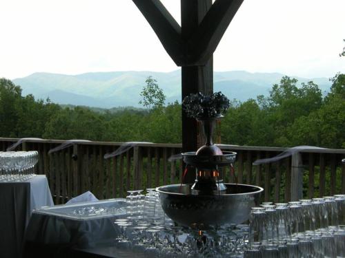 a table with wine glasses and a fountain with a view at Nantahala Village in Bryson City