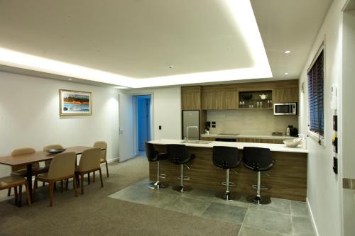 a kitchen with a bar and a table and chairs at Regal Palms Resort in Rotorua