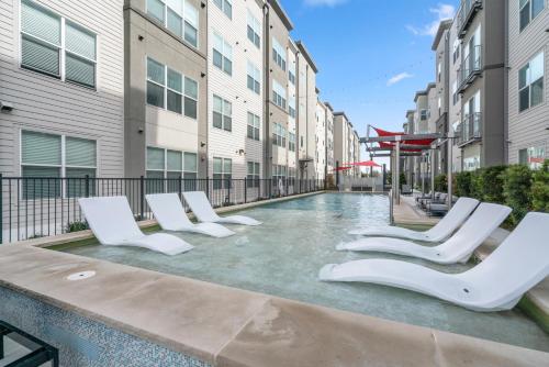 a swimming pool with lounge chairs in a building at Kasa Highland Park Dallas in Dallas