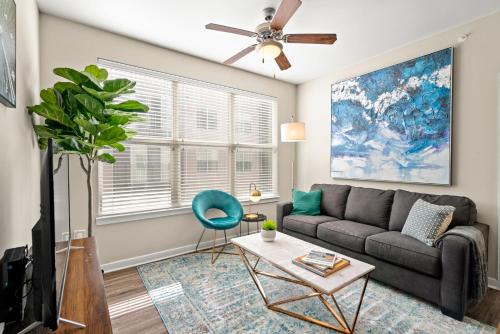 Kasa Highland Park Dallas في دالاس: غرفة معيشة مع أريكة ومروحة سقف