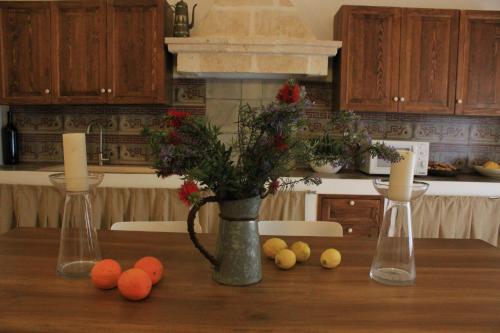 a table with a vase with flowers in a kitchen at Masseria Zambardo in San Vito dei Normanni