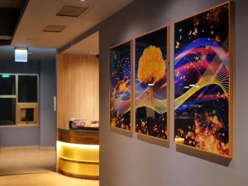 a group of paintings on a wall in a room at Modern Inn in Taichung