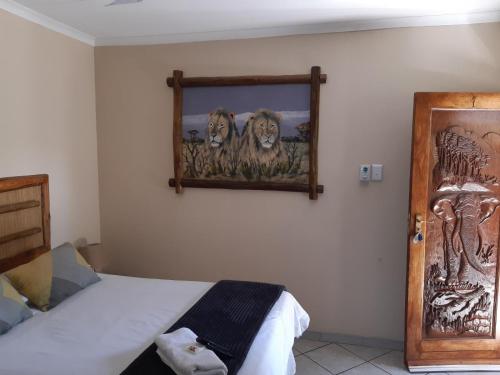 a bedroom with a picture of lions on the wall at Lephalale Guest House in Ellisras