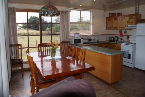 a kitchen with a table and chairs and a kitchen with a table and a kitchen at AAA Granary Accommodation in Promised Land