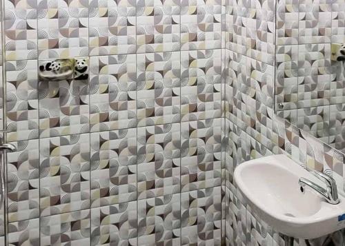 a bathroom with a sink and a shower with tiled walls at RedDoorz near Taman Wisata Alam Punti Kayu Palembang 2 in Sukarami