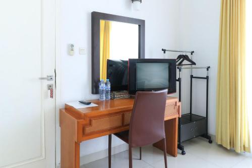 a desk with a computer and a television on it at Ge JacMart Homestay Makassar in Makassar