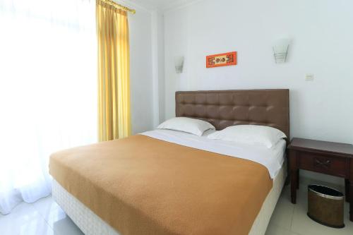 Tempat tidur dalam kamar di Ge JacMart Homestay Makassar