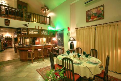 a dining room with a table and a bar at Saku Boutique Homestay in Saraphi