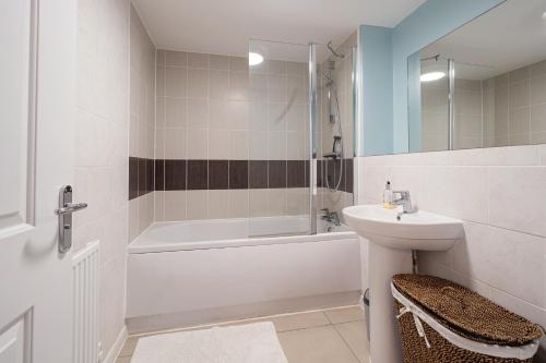 ein Badezimmer mit einem Waschbecken, einer Badewanne und einem WC in der Unterkunft Modern Townhouse - Sleeps up to 6 in Maidenhead