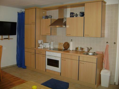 una cocina con armarios de madera y fregadero en Ferienwohnung Hofeditz, en Radeberg