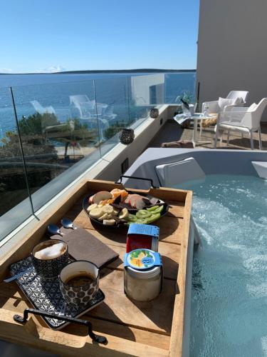 una bandeja de comida en una mesa junto a la piscina en Villa Natura luxury apartments, en Mandre