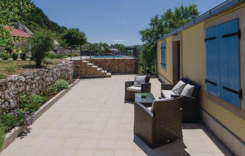 - une terrasse avec 2 chaises et un bâtiment avec des escaliers dans l'établissement Holiday Home Stari Zoganj, à Potomje