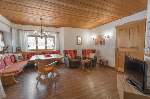 uma sala de estar com um sofá e uma mesa em Ferienwohnungen Alpentraum - Landhaus am Bächle em Oberstdorf