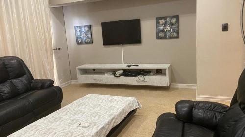 a living room with a couch and a tv at 1424 @ Jasmine in Hartbeespoort
