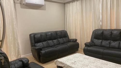 a living room with a leather couch and a chair at 1424 @ Jasmine in Hartbeespoort