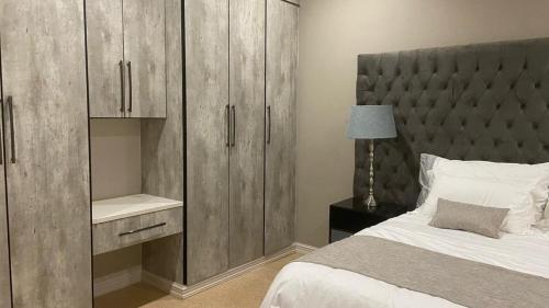a bedroom with a bed and a large wooden cabinet at 1424 @ Jasmine in Hartbeespoort