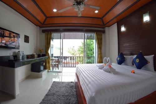 een slaapkamer met een groot bed en een groot raam bij Vivi Boutique Room Hotel SHA Plus in Rawai Beach