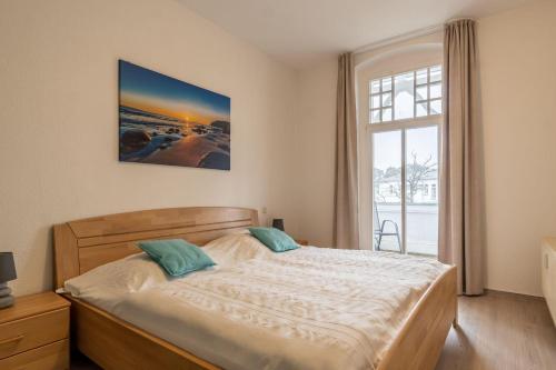 a bedroom with a large bed and a window at Haus Metropol 2-Raum-Apartment - Nr. 10 in Binz