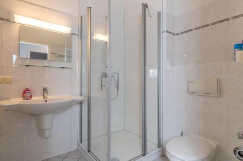 ein Bad mit einer Dusche, einem WC und einem Waschbecken in der Unterkunft Haus Metropol 2-Raum-Apartment - Nr. 10 in Binz