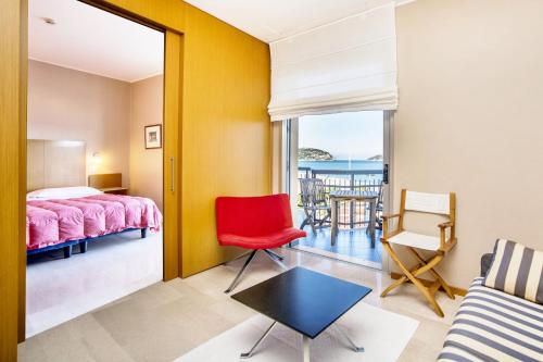 1 dormitorio con cama y vistas al océano en Hotel Tirreno, en Spotorno