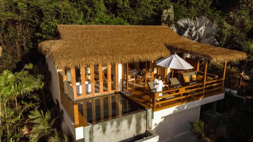 ラマイにあるWild Cottages Luxury and Natural - SHA Extra Plus Certifiedの傘付きの建物の頭上