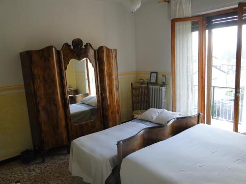 a bedroom with two beds and a large mirror at Il Caslett in Villa Guardia