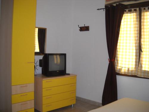 a tv sitting on a dresser in a bedroom at Munduge b&b in Lotzorai