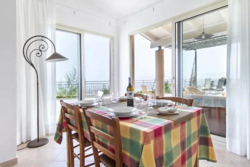 ein Esszimmer mit einem Tisch mit Stühlen und Fenstern in der Unterkunft villa Sun in Alcamo