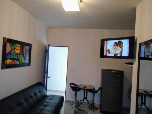 a living room with a couch and a tv at Estancias ALELI ,entre/sal.aerpto,terml traspt,CC.unico,baseMFS in Cali