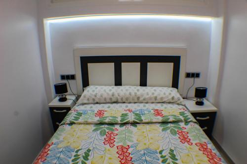 sypialnia z łóżkiem i dwoma szafkami nocnymi z lampkami w obiekcie LOS RANCHOS PREMIUM Levante Beach w mieście Benidorm