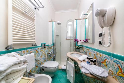a bathroom with a toilet, sink, and bathtub at Hotel San Lorenzo Thermal Spa in Ischia