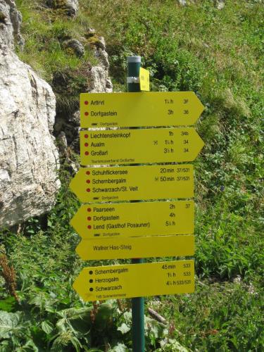 a yellow sign with arrows pointing in different directions at Bergparadies - inklusive Eintritt in die Alpentherme in Dorfgastein