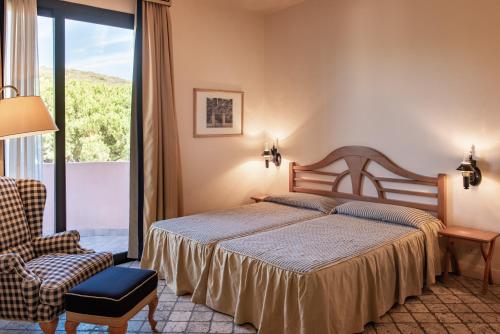 Roccamare Resort - Casa di Levante في كاستيغليون ديلا بيسكايا: غرفة نوم بسرير وكرسي ونافذة