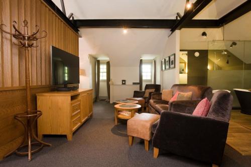 a living room with couches and a flat screen tv at Hotel Du Vin & Bistro York in York