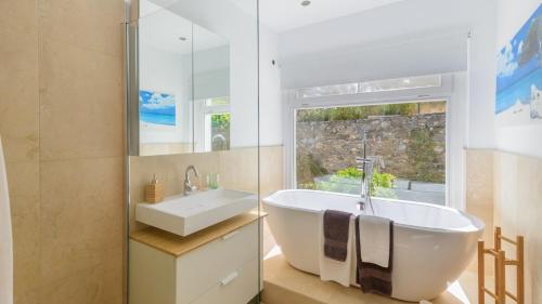 een badkamer met een bad, een wastafel en een raam bij Villa Valparaiso Alhama de Granada by Ruralidays in Alhama de Granada