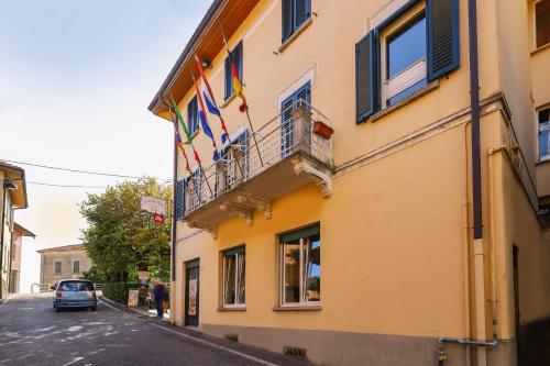 un bâtiment jaune avec des drapeaux sur son côté dans l'établissement Locanda Milano 1873, à Brunate