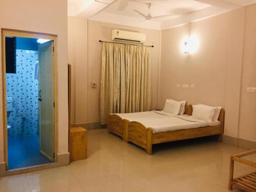 1 dormitorio con 1 cama y puerta de cristal en Lake Side Resort Neermahal en Melāghar