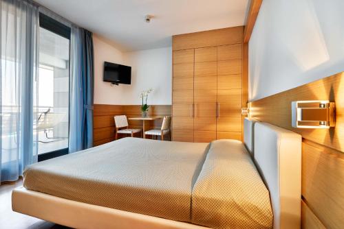ein Hotelzimmer mit einem Bett und einem Tisch in der Unterkunft Hotel Fonzari in Grado