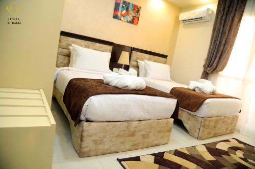 Habitación de hotel con 2 camas y almohadas blancas en Jewel Dokki Hotel en El Cairo