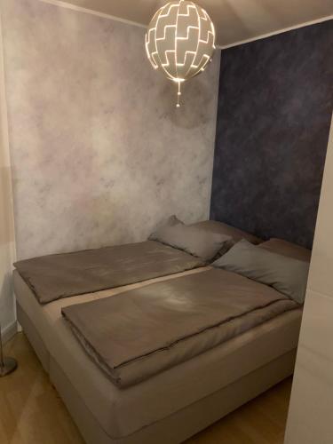 a bed in a room with a chandelier at Mini-Ferien-Suite Hildesheim in Hildesheim