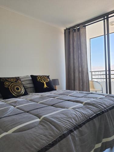 une chambre avec un grand lit avec une grande fenêtre dans l'établissement AMUNATEGUI 213 Centro Iquique Ejecutivos, à Iquique