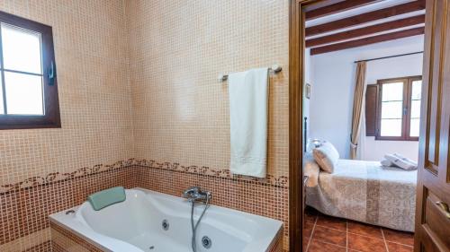 y baño con bañera y espejo. en Casa La Encina Alora by Ruralidays, en Álora