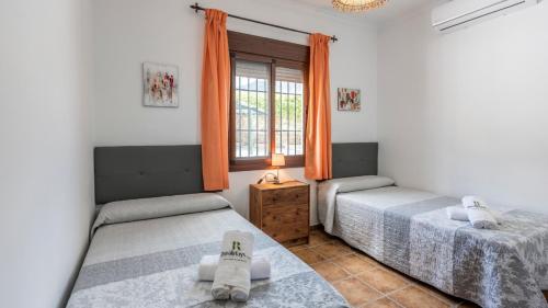 two beds in a room with a window at Casa Los Marjales El Gastor by Ruralidays in El Gastor