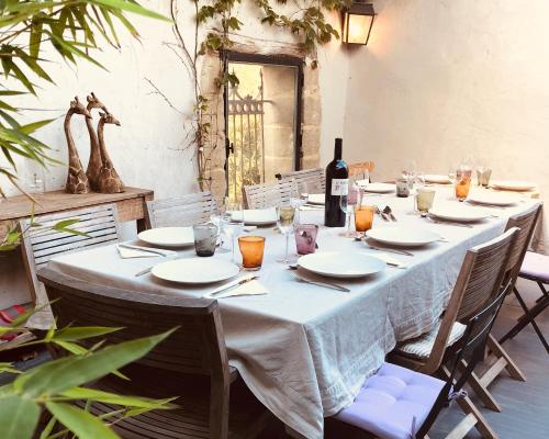 - une table avec un chiffon de table blanc et une bouteille de vin dans l'établissement La Maison Blanche Uzès, à La Bastide-dʼEngras