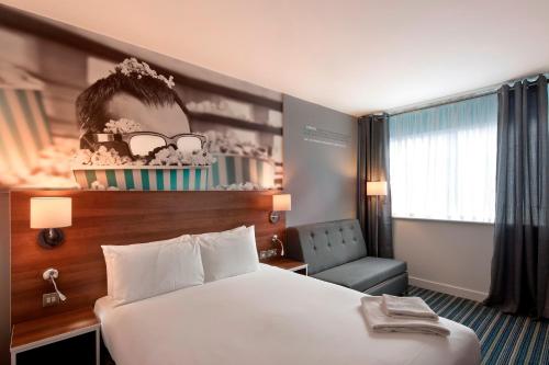 a hotel room with a bed and a chair at Heeton Concept Hotel - City Centre Liverpool in Liverpool